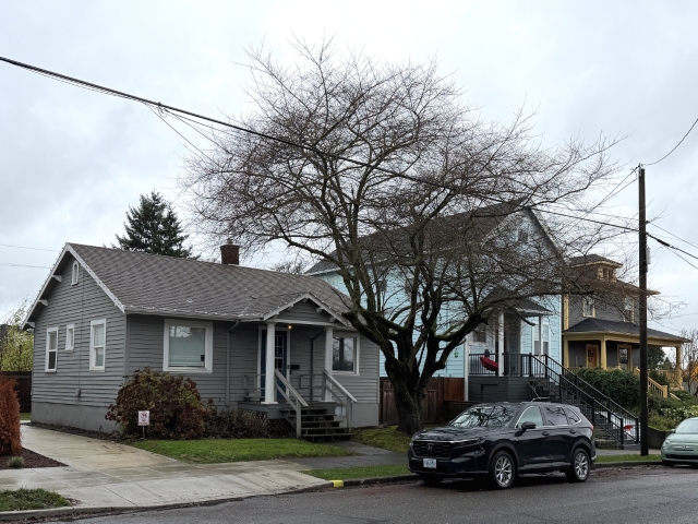 Single-family home on 5,000 sq ft RM2-zoned lot immediately adjacent to new three-story, 16-unit multifamily building at 11 NE 55th Ave, Portland — illustrating highest-and-best-use risk for Certified Residential appraisers in transitional RM1/RM2 zones, December 2025