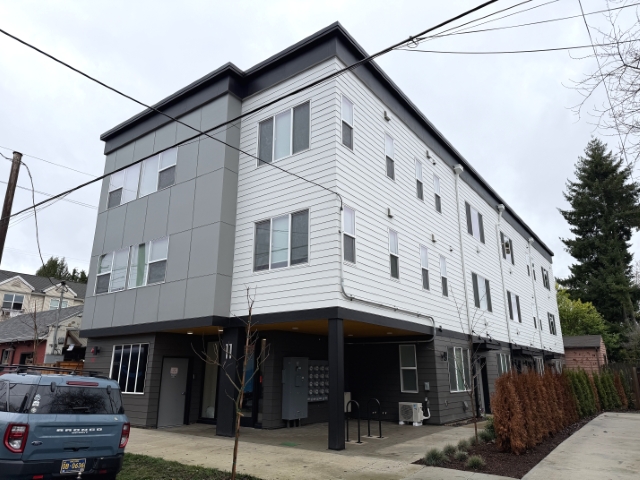 New three-story, 16-unit multifamily on 5,000 sq ft CM2 lot at 11 NE 55th Ave, Portland, exemplifying H&BU shifts in RM1/RM2 transitional zones post-single-exit stairwell guidelines.