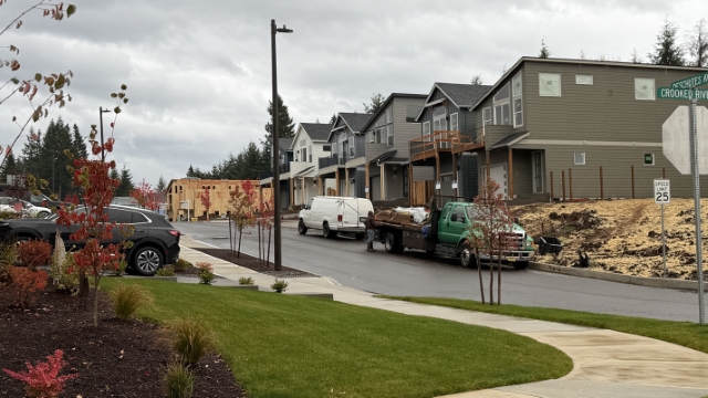New single-family homes under construction in a vested subdivision in Sandy, Oregon. Section of completed homes with a framed house in the distance.
