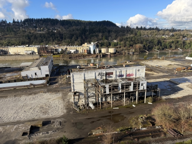 Active demolition and site clearance with excavator at the former Blue Heron mill property in Oregon City, showing progress toward redevelopment.